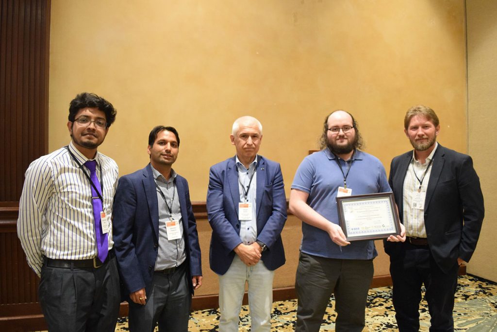 Himanshu Thapliyal posing with a few other men and the best paper award winner at the 2024 IEEE Computer Society Annual Symposium