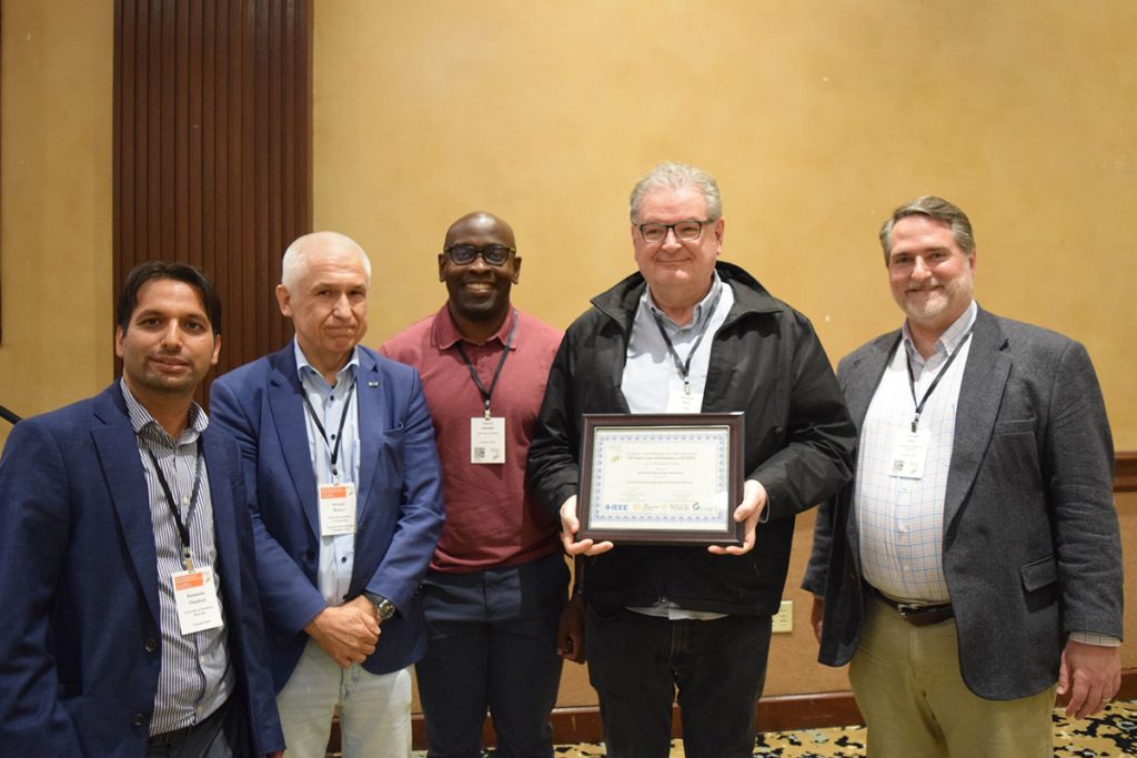 Himanshu Thapliyal and Garrett Rose posing with a few other men and the best paper winner at the 2024 IEEE Computer Society Annual Symposium