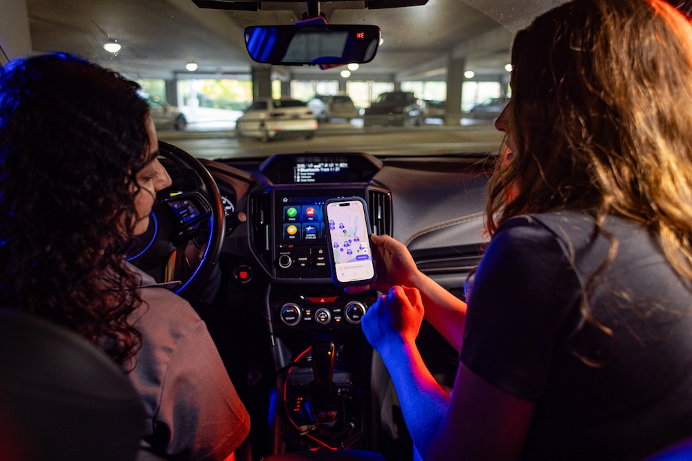 female students using VolPark app while sitting in their car