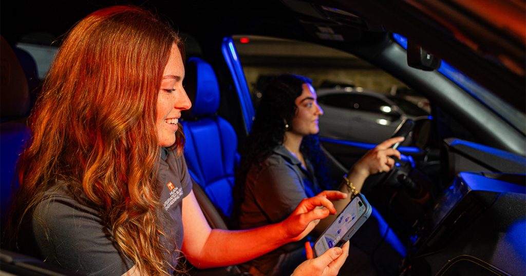 female students sitting in a car using the VolPark app