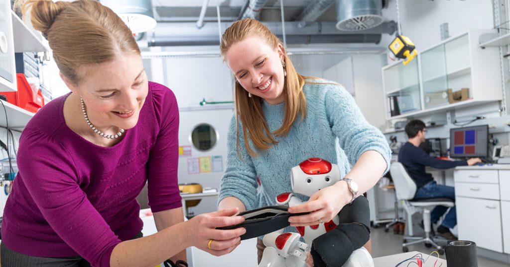 Rachael Beville Burns and student working on a robot