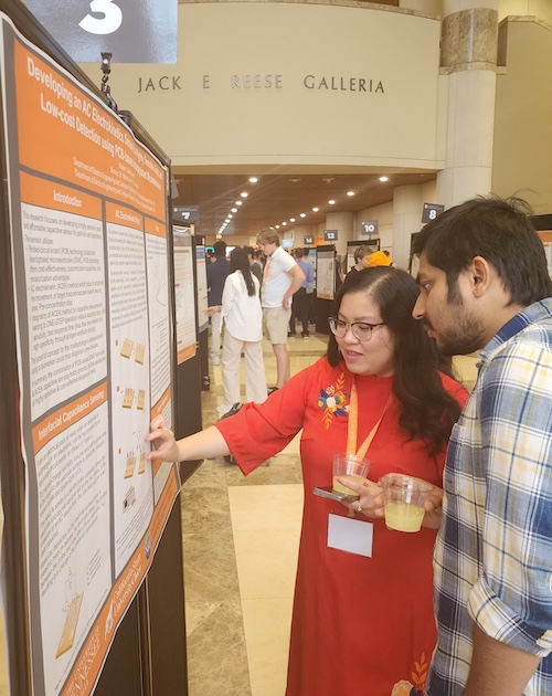 student and faculty member discussing a project at a poster board