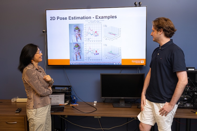 Hairong Qi speaking with another professor