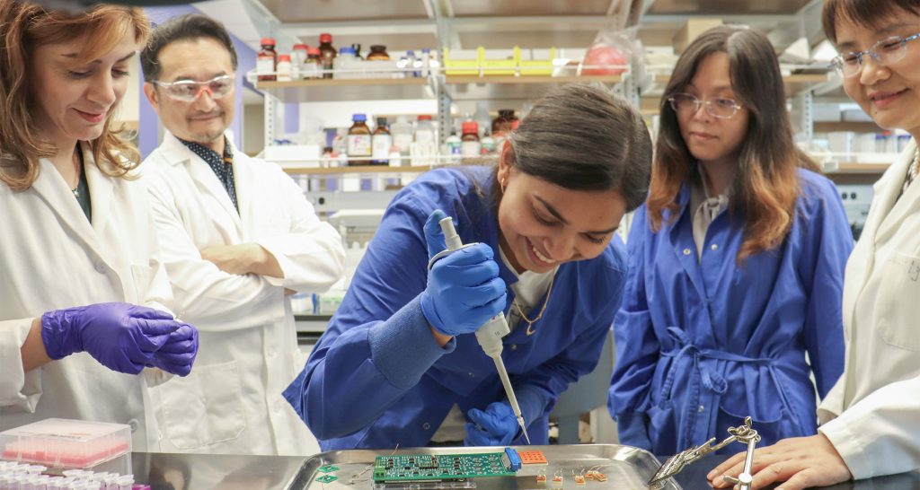 students, Jayne Wu, Shigetoshi Eda working on a PTSD device in a lab