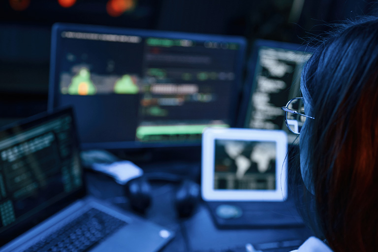 Woman looking at multiple monitors
